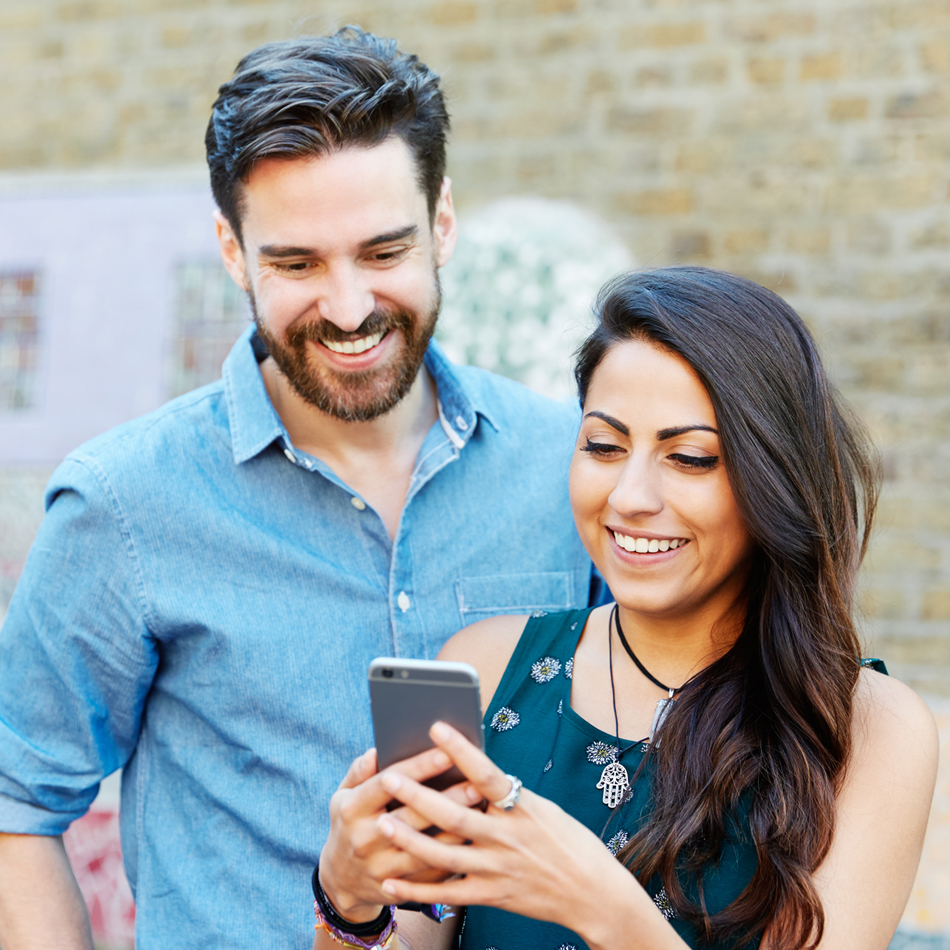 Couple on a shared cell phone smiling